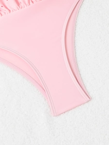 Detail of pink swimsuit bottom featuring delicate ruffled lace trim and fine stitching