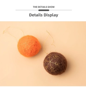 Detail of wool felt Christmas balls with gold snowflake embroidery in orange and brown