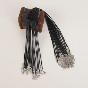 Multiple black wax cord necklaces with silver lobster clasps on vintage wooden box