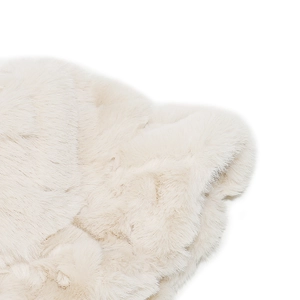Macro detail of plush cream faux fur texture showing soft fluffy winter hat material