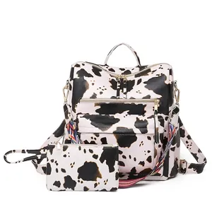 Fashionable cow print backpack and clutch set with colorful woven strap on white background