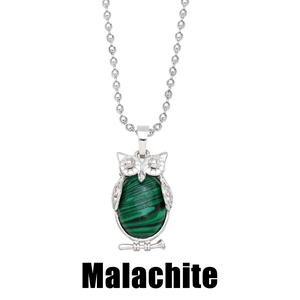 Macro detail of silver owl pendant featuring green malachite stone and beaded chain