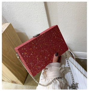 Detail of red glitter box bag with star sequins and silver metal chain strap