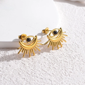 Detailed close-up of vintage golden evil eye stud earrings with black sunburst details