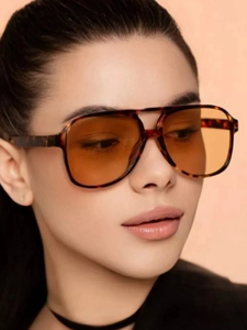 Close-up of retro aviator sunglasses with tortoise frame and orange lenses