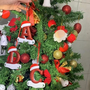 Close-up of red glitter alphabet Christmas tree ornaments with miniature Santa hats