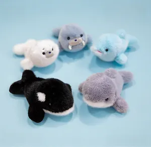 Vue détaillée de dessus de cinq jolies peluches d'animaux marins sur un fond bleu clair