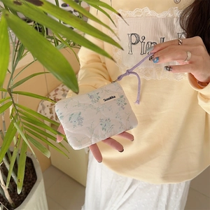 Detail of floral quilted cotton coin purse with zipper closure and purple lanyard