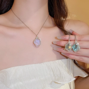 Detail of handcrafted wire-wrapped natural crystal pendants in purple and blue