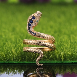 Detalle del anillo de serpiente dorada con circonitas azules y escamas grabadas
