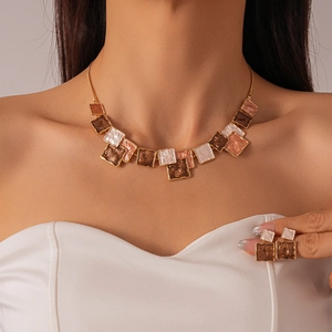 Detail of geometric square oil drip necklace and earrings set on female model