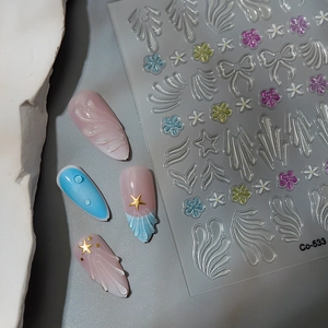 Makroansicht von 3D-Relief-Nagelaufklebern mit Blumen, Muscheltexturen und Schleifendesigns