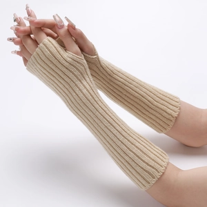 Detail of beige ribbed knit arm warmers showing thumb hole and soft wool texture
