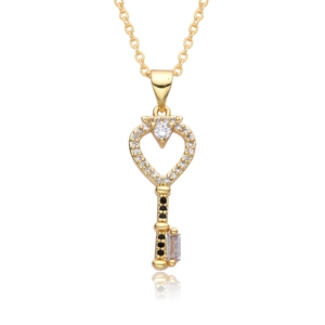 Detailed macro view of 18k gold heart key pendant with crystals and black gemstone