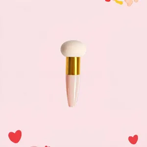 Detail of mushroom makeup sponge with gold ferrule and ergonomic pink handle for foundation