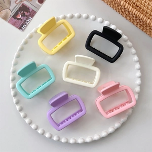 Detailed set of six square matte hair claws in various colors on a decorative pearl plate