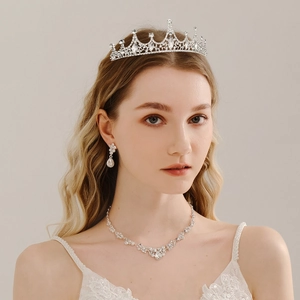 Close-up of bridal jewelry set with crystal crown, earrings and necklace on a model