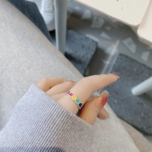 925 silver open ring with colorful enamel smiley faces on model's hand with grey sweater