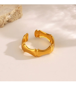 Close-up of golden bamboo joint style open ring with polished metal texture and stone detail