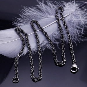 Close-up of black punk twist chain necklace with lobster clasp on a light feather