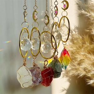 Five gold suncatchers with amethyst and natural crystals hanging in warm sunlight