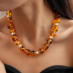 Detailed view of amber acrylic beads with golden metal spacers on a vintage necklace