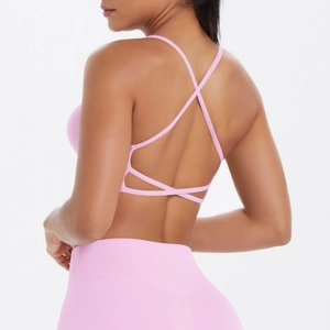 Détail d'un soutien-gorge de sport rose avec bretelles croisées et design yoga