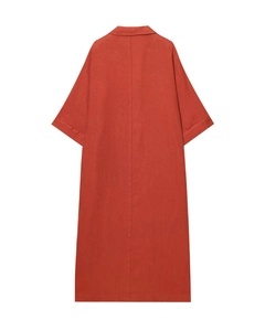 Détail macro de la texture en lin orange brûlé et coutures arrière de la robe maxi