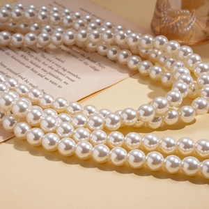 Detail of warm white pearl multi-strand necklace with lustrous surface on vintage background