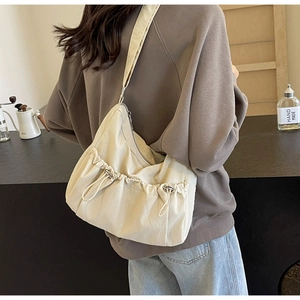Detail of beige large nylon crossbody bag with drawstring and wide shoulder strap