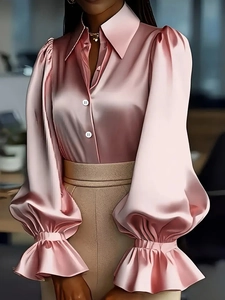 Dettaglio camicia in raso rosa con maniche a sbuffo ed eleganti polsini con volant lucidi