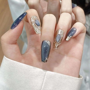 Blue cat eye press-on nails with gold embossed relief and glitter in coffin shape
