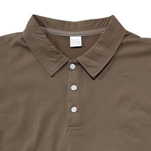 Detail of tan polo shirt collar with three buttons and internal fabric labels