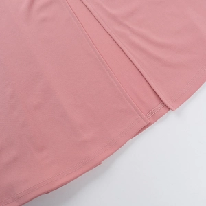 Detail of pink knitted dress featuring high-quality stitching and elegant side slit hem