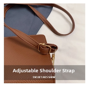 Detail of brown litchi leather bag showing adjustable shoulder strap with gold buckle