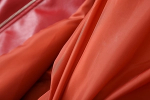 Detailed macro shot of red glossy faux leather fabric and smooth interior lining