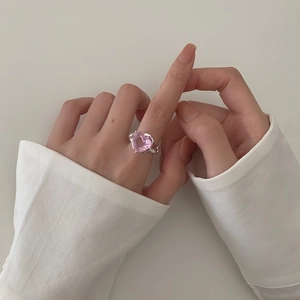 Elegant 925 sterling silver ring with pink heart zircon on hand of woman in white shirt