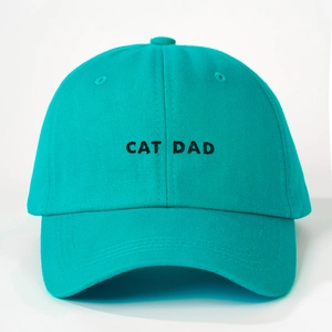 Close-up of black CAT DAD embroidery on a green cotton baseball cap with ventilation eyelets