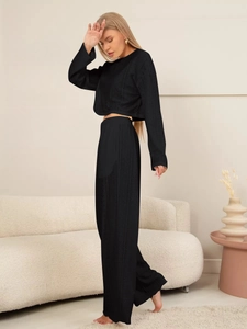 Détail d'un ensemble de détente noir avec texture en maille ajourée et pantalon large