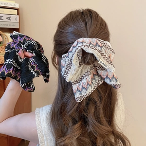 Chouchous nœuds tricotés avec motifs zigzag en noir et crème portés sur cheveux