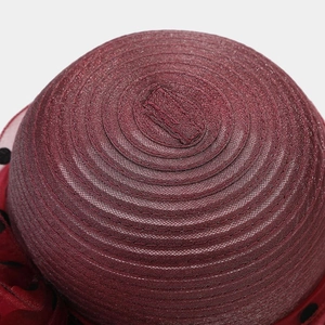 Detail view of burgundy organza hat showing spiral stitching and polka dot mesh
