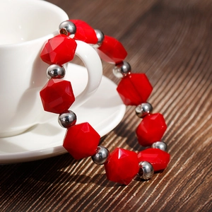 Bohemian style beaded bracelet with vibrant red geometric beads and silver metal balls