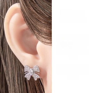Macro detail of a silver butterfly cartilage piercing stud with micro-paved cubic zirconia