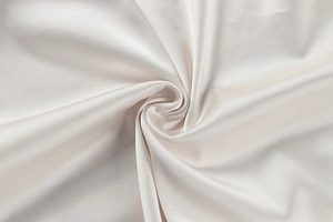 Detailed view of the luxury cream satin fabric with elegant silk sheen and soft texture