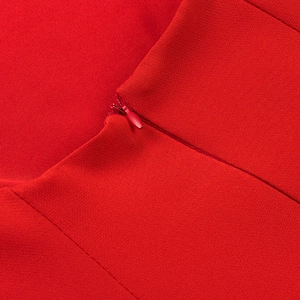 Macro detail of high-quality red ruffled dress showing invisible zipper and knit texture