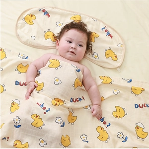 Close-up of bamboo cotton baby blanket and pillow set with yellow duck patterns