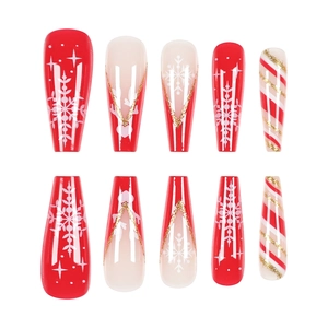 Faux ongles de Noël avec flocons de neige rouges et blancs et touches pailletées d'or