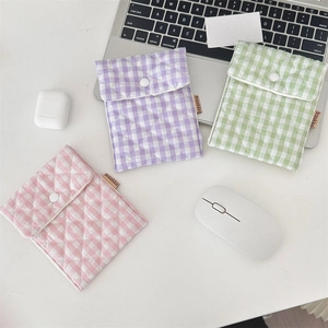 Close-up of quilted cotton storage pouches in pastel colors with white snap buttons