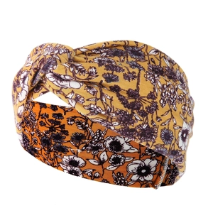 Macro detail of the paisley print knot headband in vibrant orange and yellow stretch fabric