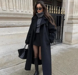 Style de rue d'un manteau long en laine noire avec col roulé gris et bottes en cuir